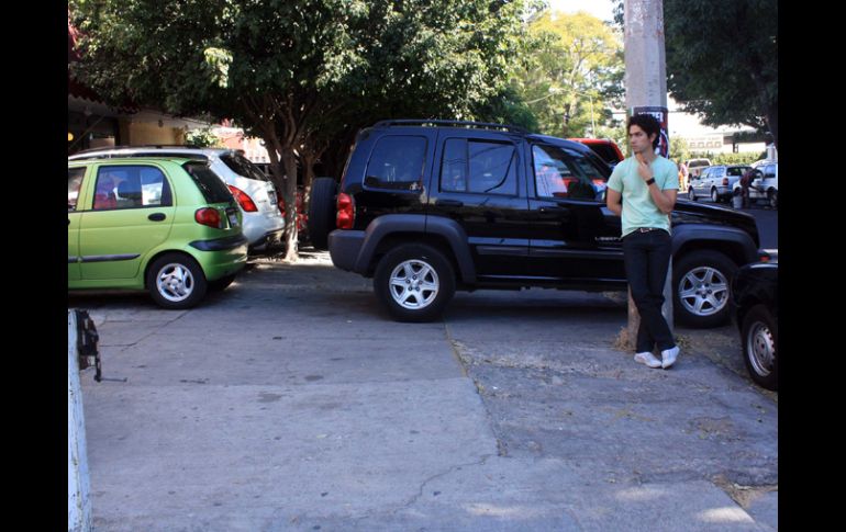 La dificultad para encontrar estacionamiento provoca que los autos invadan constantemente la banqueta. A. HINOJOSA  /