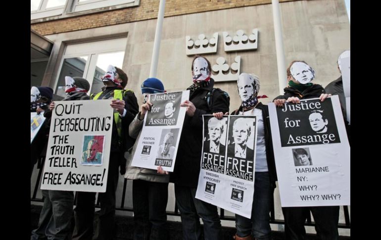 Simpatizantes de Julian Assange portan carteles en los que piden su libertad, afuera de la embajada sueca en Londres. AP  /