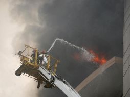 El Servicio de Bomberos y Defensa Civil informó que trabajadores quedaron atrapados en el edificio. EFE  /