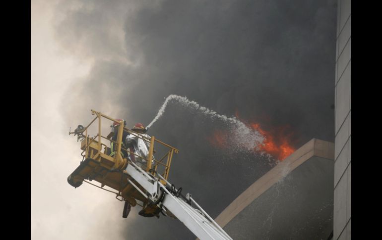 El Servicio de Bomberos y Defensa Civil informó que trabajadores quedaron atrapados en el edificio. EFE  /