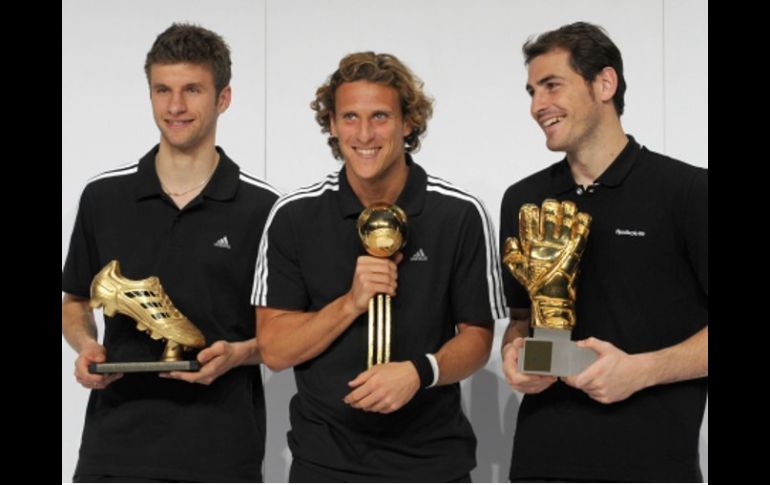 Thomas Müller, Diego Forlán e Iker Casillas posan con sus trofeos. AFP  /