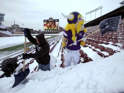 La mascota de los Vikingos retira la nieve de las butacas del estadio que será la sede del partido de la próxima semana. REUTERS  /