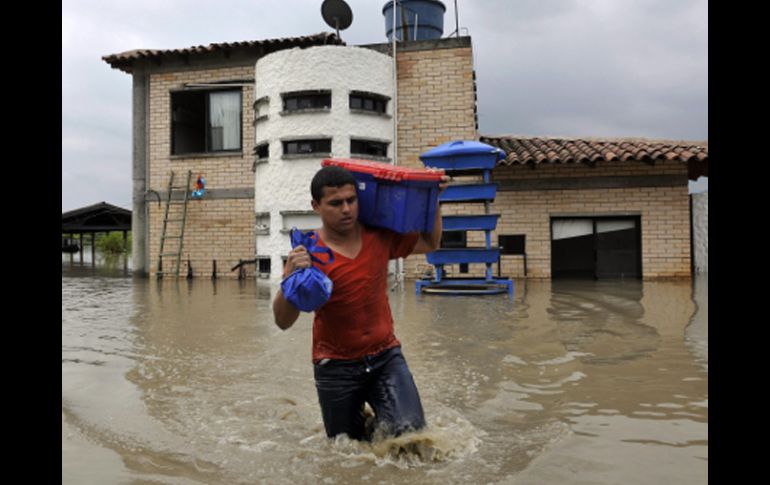 Un habitante del sector La Dolores, en zona rural de Palmira, sale con algunas de sus propiedades. EFE  /