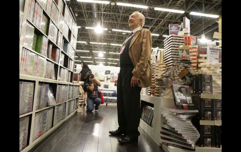 El escritor Sergio Pitol sonríe al ver que una joven le toma una fotografía en el stand del Fondo de Cultura Económica. A. CAMACHO  /