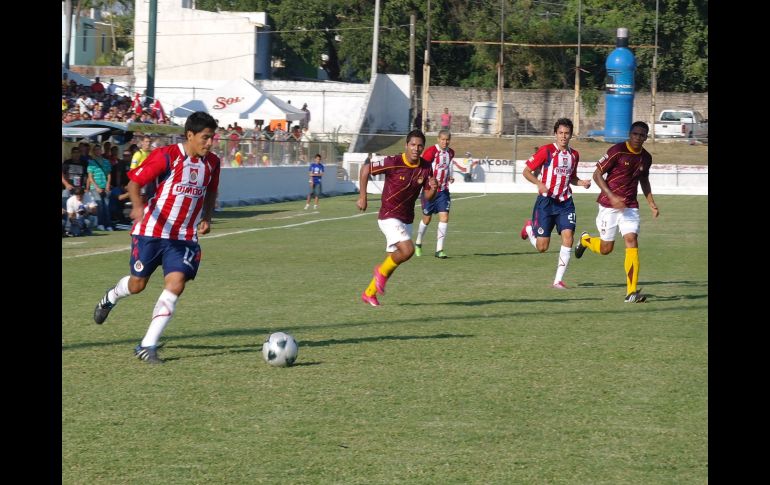 Mitchel Oviedo, de Chivas, lleva un balón, ante la mirada de sus compañeros y jugadores de Tecos. ESPECIAL  /