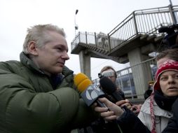 Periodistas abordan a Julian Assange, en las afueras de la estación de tren Diss, en Norfolk, Inglaterra. AFP  /