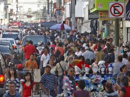 En Obregón se apretujan en total desorden compradores y vehículos particulares en plena euforia por la época decembrina. S. NÚÑEZ  /