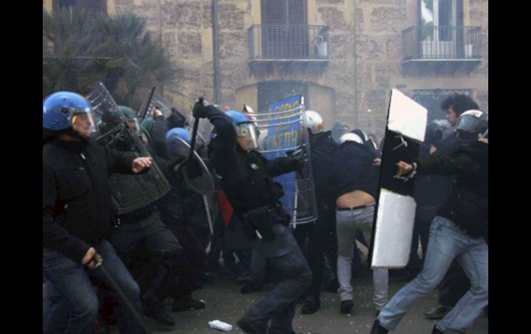Policías cargan contra un grupo de jóvenes durante los disturbios producidos cuando miles de estudiantes se manifestaban. EFE  /
