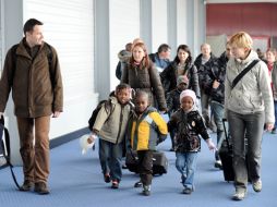 Niños haitianos con sus padres adoptivos en el aeropuerto de Roissy-en-France. AFP  /