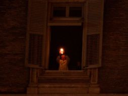 Benedicto XVI sostiene el Cirio de la Paz colocado en la ventana de su apartamento. REUTERS  /