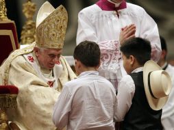 El Papa saluda a dos niños durante el ofertorio en la misa de Navidad. AP  /