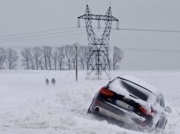 Un vehículo permanece bloqueado por la nieve que invade a varios países de Europa. EFE  /