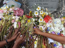 Personas en Sri Lanka colocan flores en memoria de las víctimas del tsunami. AFP  /