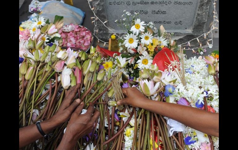 Personas en Sri Lanka colocan flores en memoria de las víctimas del tsunami. AFP  /