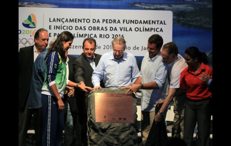 El presidente del COI, Jacques Rogge (c) descubre la piedra que simboliza el inicio de las obras de la Villa Olímpica. EFE  /