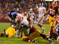 Brandon Jacobs, de Gigantes, anota, a pesar del choque con Rocky McIntosh, de Washington. AP  /