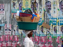 Haitiana caminando por las calles de Puerto Príncipe cubiertas de propaganda política de los candidatos. REUTERS  /