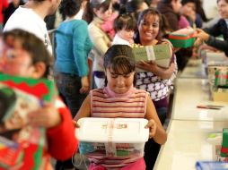 Una niña observa el regalo que le fue dado en el evento por el Día de los Reyes Magos, en Calle 2. A. CAMACHO  /