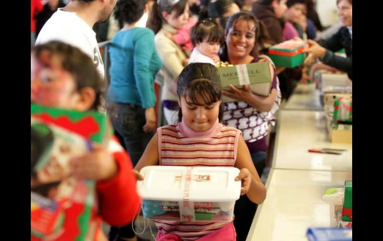 Una niña observa el regalo que le fue dado en el evento por el Día de los Reyes Magos, en Calle 2. A. CAMACHO  /