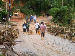 Varias personas caminan, por una carretera bloqueada en el sector de Santa Rita en Teresópolis (Brasil). EFE  /