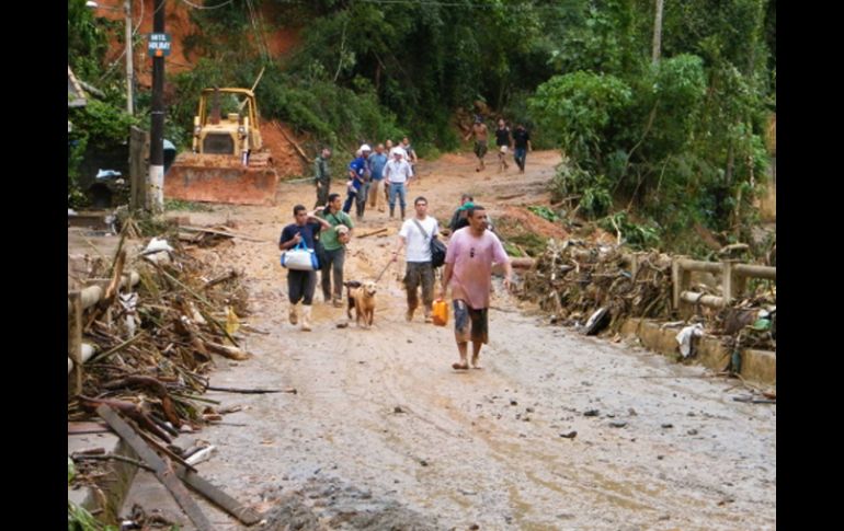 Varias personas caminan, por una carretera bloqueada en el sector de Santa Rita en Teresópolis (Brasil). EFE  /