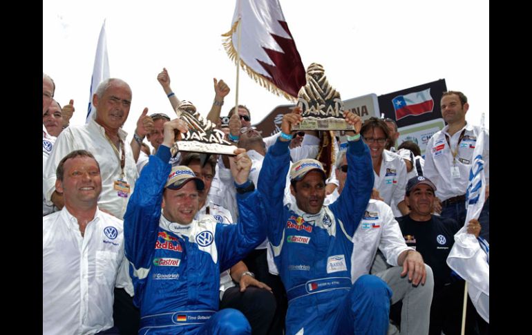 Al-Attiyah (derecha) y su copiloto Timo Gottschalk festejan el triunfo. AP  /