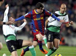 Messi (centro) trata de avanzar ante la marca de dos zagueros del Racing de Santander. EFE  /