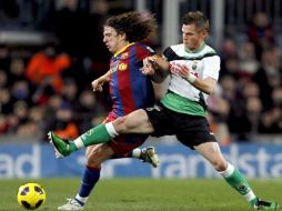 El defensa del FC Barcelona Carles Puyol (i) y el delantero del Racing de Santader Nils Markus Rosenberg luchan por el balón. EFE  /