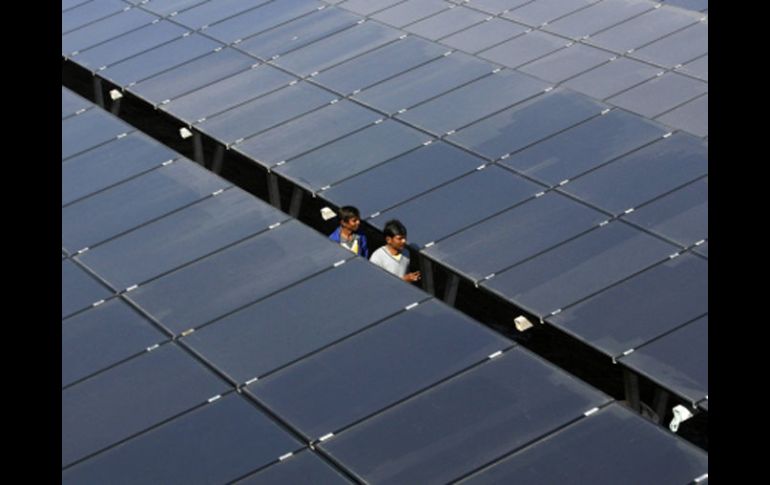 Trabajadores limpian los receptores solares en la inauguración de una granja de energía alternativa.  REUTERS  /