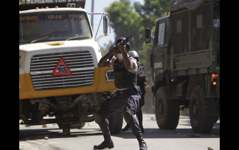 Policías haitianos se enfrentan con manifestantes que se niegan a la salida del candidato Jude Celestin. AP  /