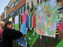 En las escuelas, los niños pegan dibujos en los que expresan sus mejores deseos a Nelson Mandela. AFP  /