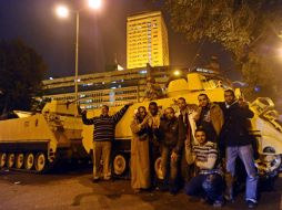 Manifestantes muestran la señal de la victoria junto a varios vehículos armados. EFE  /