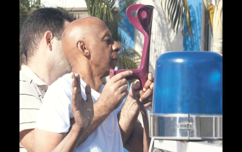 Un policía sube a Guillermo Fariñas a la patrulla. El disidente intentaba colocar una ofrenda en un monumento a José Martí. EFE  /