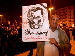 Un manifestante muestra el retrato del rostro del presidente Mubarak.  /