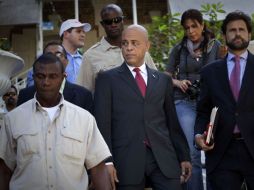 El candidato a la presidencia de Haití, Michel Martelly, camina rodeado de guaruras después de la conferencia en Puerto Príncipe. AP  /