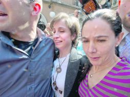 Amigos escoltan a Carmen Aristegui a la salida de la conferencia de prensa en la que explicó el motivo de su despido de MVS Radio. AFP  /