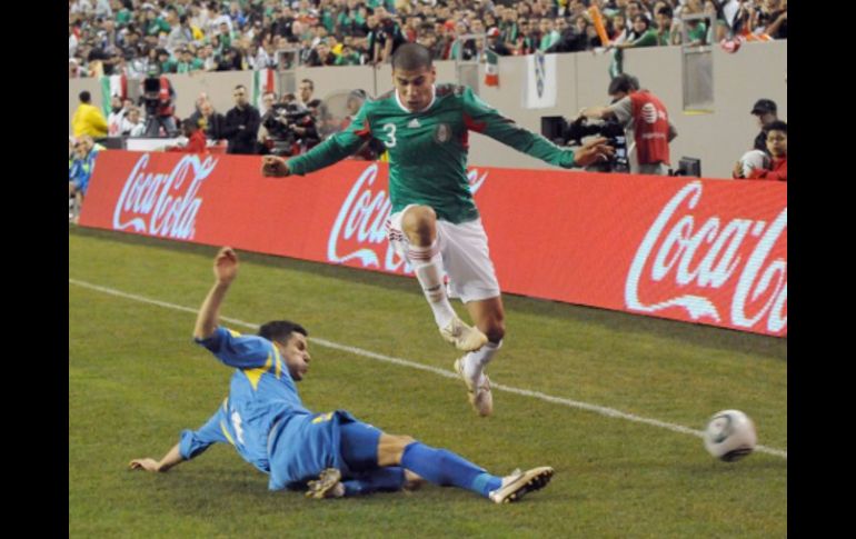 Carlos Salcido defendiendo el balón ante un integrante de la Selección de Bosnia en el partido amistoso. AFP  /