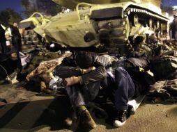 Manifestantes descansan junto a un tanque. EFE  /