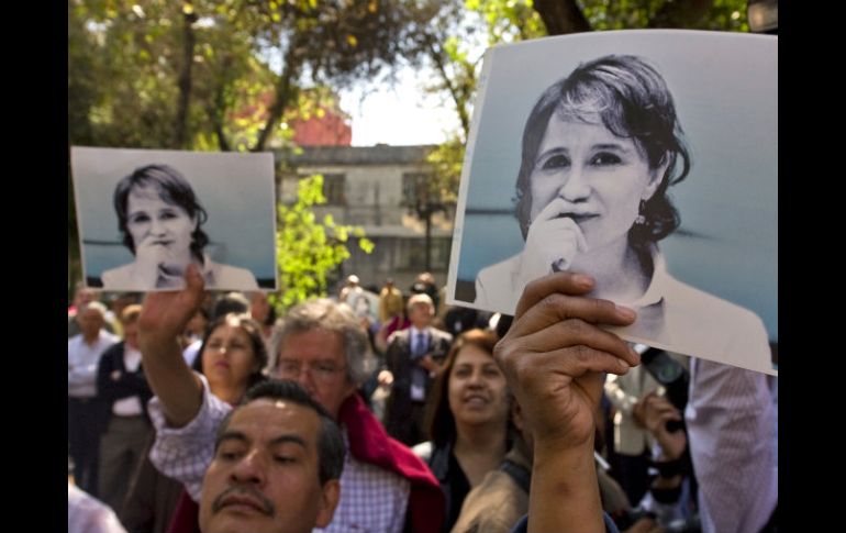 Periodistas manifestaron con  fotos que muestran a Aristegui con la mano en la boca. AFP  /