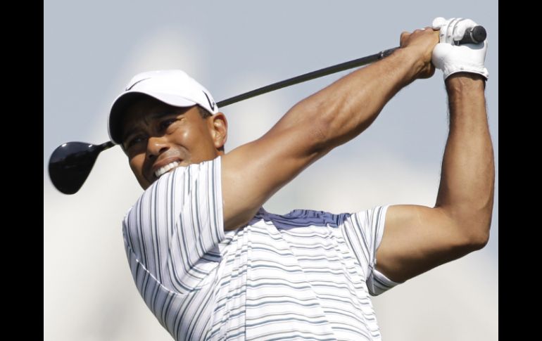 Tiger Woods observa su tiro de salida en el hoyo tres. AP  /