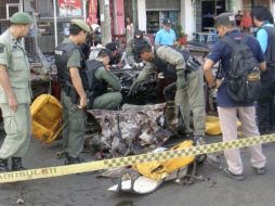 Policías artificieros inspeccionan los daños ocasionados por la explosión de un coche bomba en Narathiwat. EFE  /