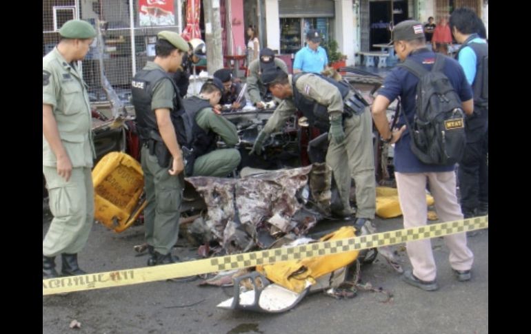 Policías artificieros inspeccionan los daños ocasionados por la explosión de un coche bomba en Narathiwat. EFE  /