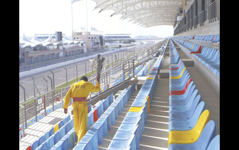 Un trabajador limpia los asientos de la pista del Circuito Internacional de Bahrein. GETTY IMAGES SPORT  /