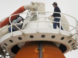 Empleados de la NASA trabajan en el tanque de combustible exterior del Discovery. AFP  /