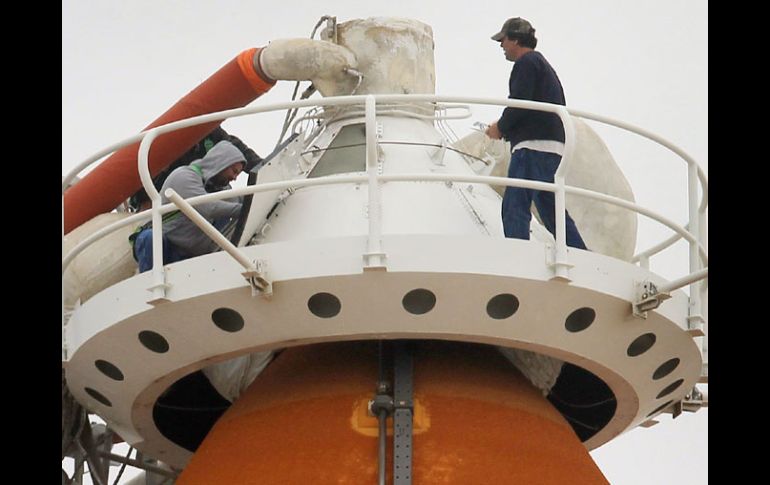 Empleados de la NASA trabajan en el tanque de combustible exterior del Discovery. AFP  /