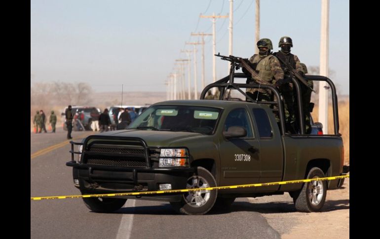 Vigilancia en el lugar donde fueron hallados los cuerpos de tres integrantes de la familia Reyes. REUTERS  /