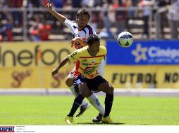 Joao Rojas (de frente) cubre la pelota, ante la marca de Daniel Guerrero. MEXSPORT  /