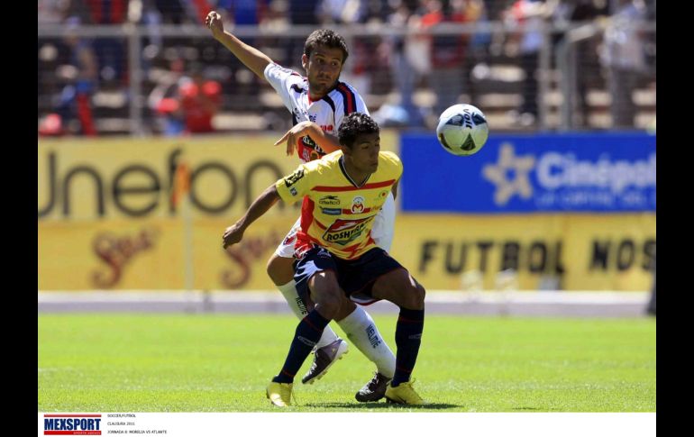 Joao Rojas (de frente) cubre la pelota, ante la marca de Daniel Guerrero. MEXSPORT  /