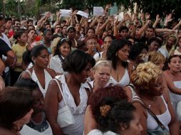 Damas de Blanco, rodeadas por oficialistas con carteles que dicen: 'abajo las viejas brutas'. AP  /