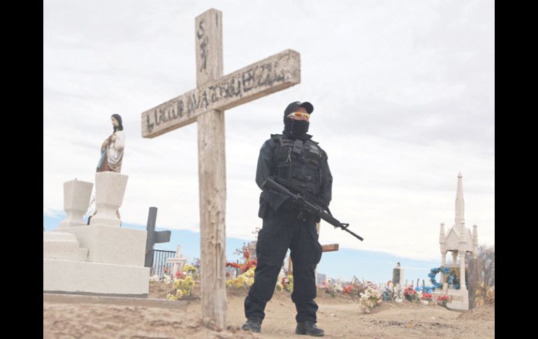 Imagen de archivo en la que un policía hace guardia durante el entierro de los familiares de Sara Salazar. REUTERS  /